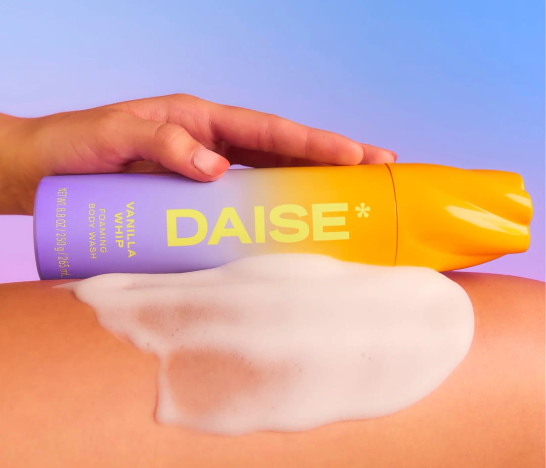 HAMYNAT DAISE Vanilla Whip foaming body wash in an ombre bottle with rich white mousse lather applied to skin