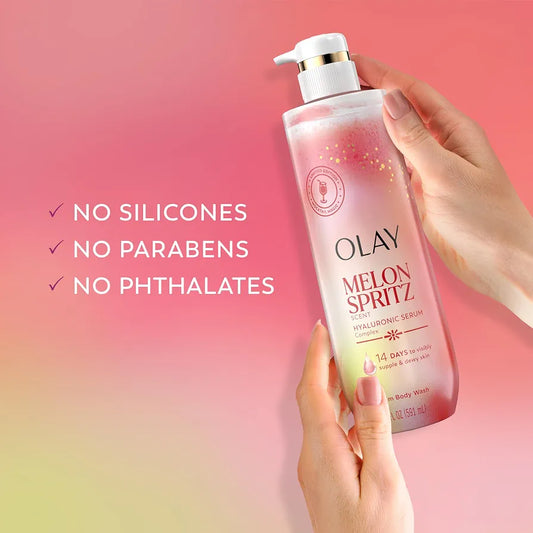 HAMYNAT Olay Melon Spritz Hyaluronic Serum body wash in a pump bottle held by hands against a pink gradient background.
