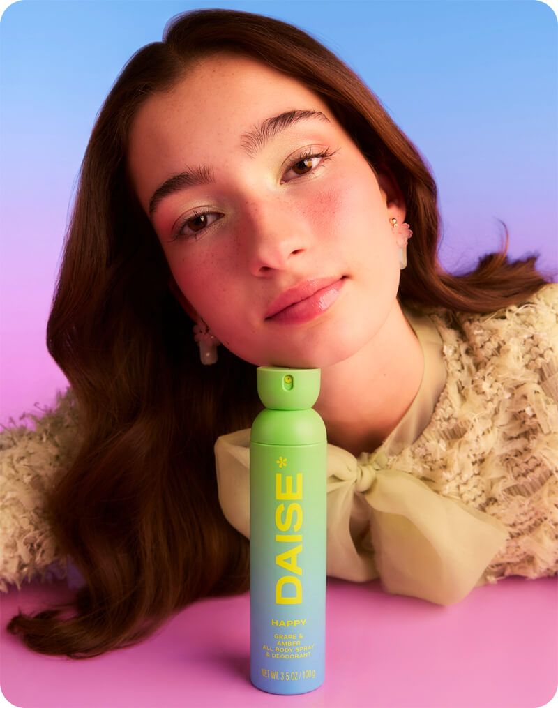 Daise Happy Grape & Amber All Body Spray & Deodorant 120ml held by a model