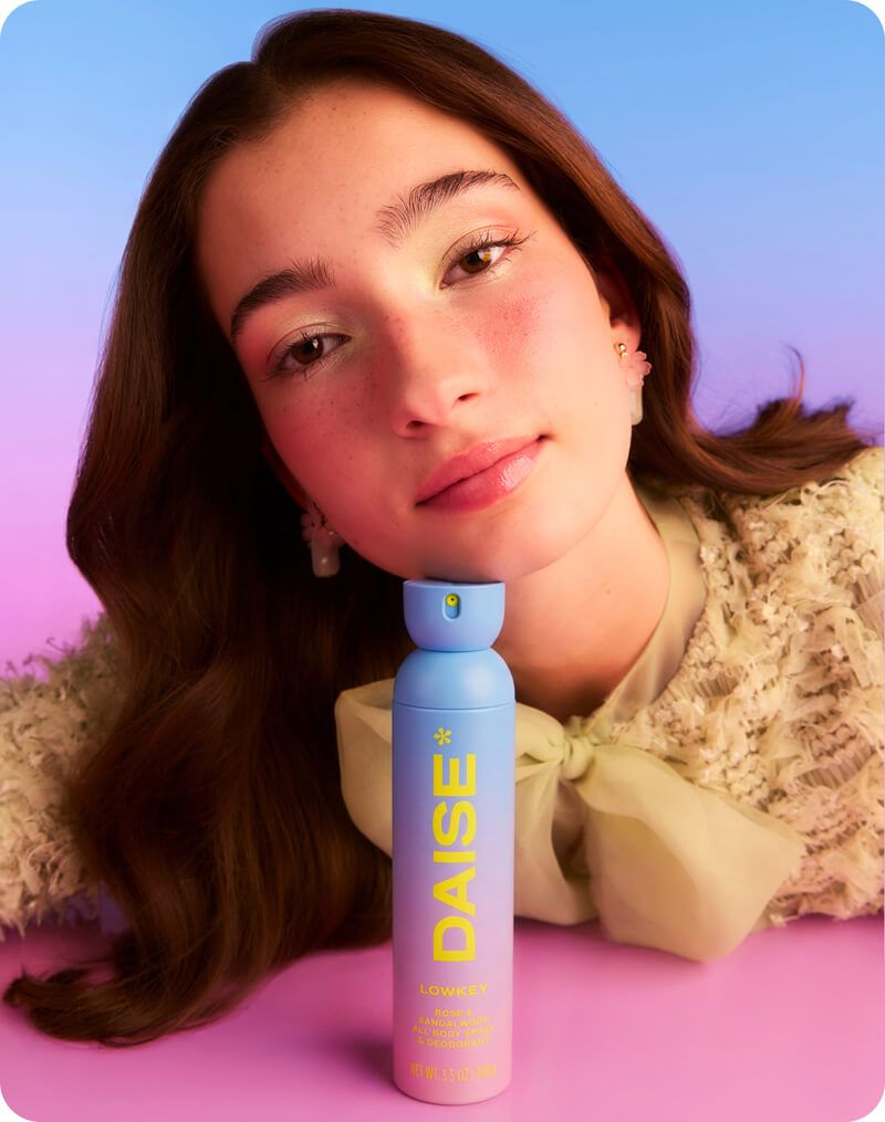 Daise Lowkey Rose & Sandalwood All Body Spray & Deodorant 120ml held by a model