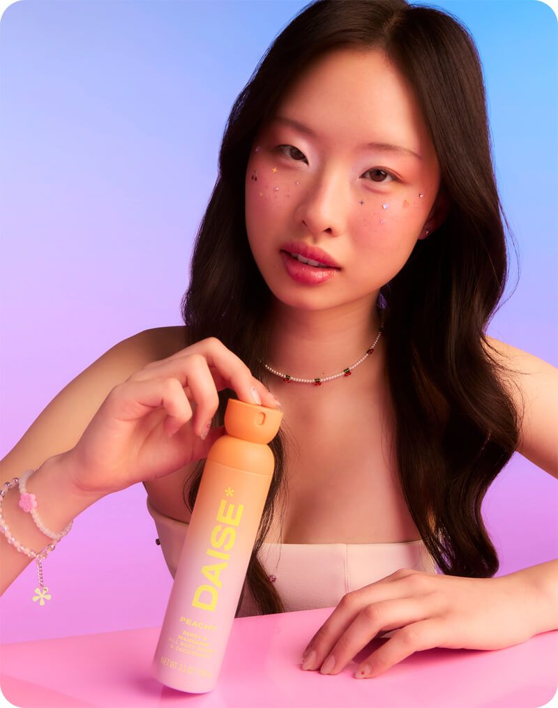 Daise Peachy Berry & Mandarin All Body Spray & Deodorant 120ml held by a model