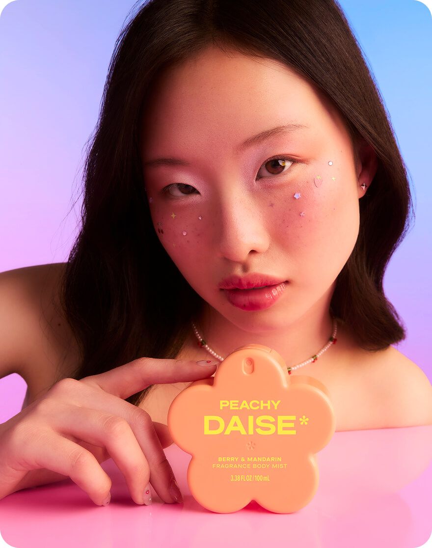 Daise Peachy Berry & Mandarin Fragrance Body Mist 100ml held by a model