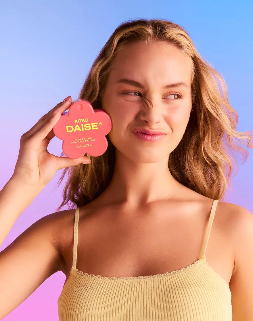 Daise XOXO Rose & Amber Fragrance Body Mist 100ml held by a model