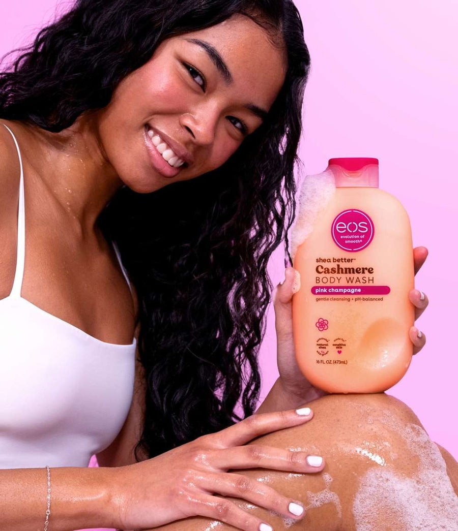 HAMYNAT model holding a bottle of EOS Cashmere Pink Champagne body wash against a bright pink background