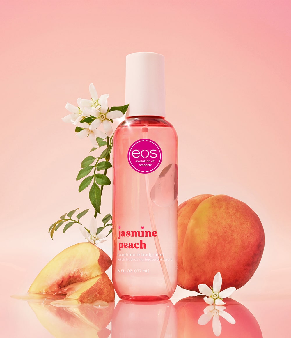 EOS Jasmine Peach body mist beside peaches and jasmine flowers