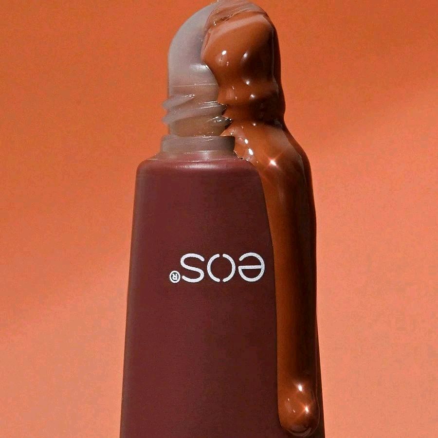 HAMYNAT eos Salted Caramel hydrating lip treatment in a brown tube with glossy caramel product dripping from the top