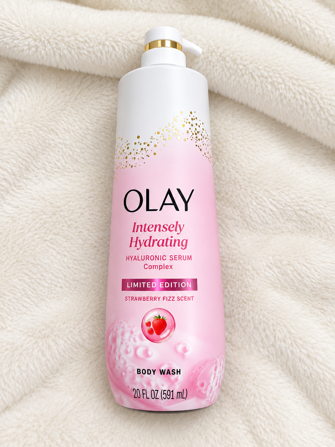 HAMYNAT Olay Intensely Hydrating Body Wash with Hyaluronic Serum in a pink bottle with strawberry scent on a blanket