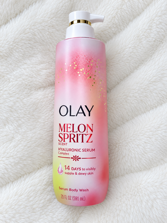HAMYNAT Olay Melon Spritz Hyaluronic Serum Body Wash in a pink and yellow gradient pump bottle on a white fleece