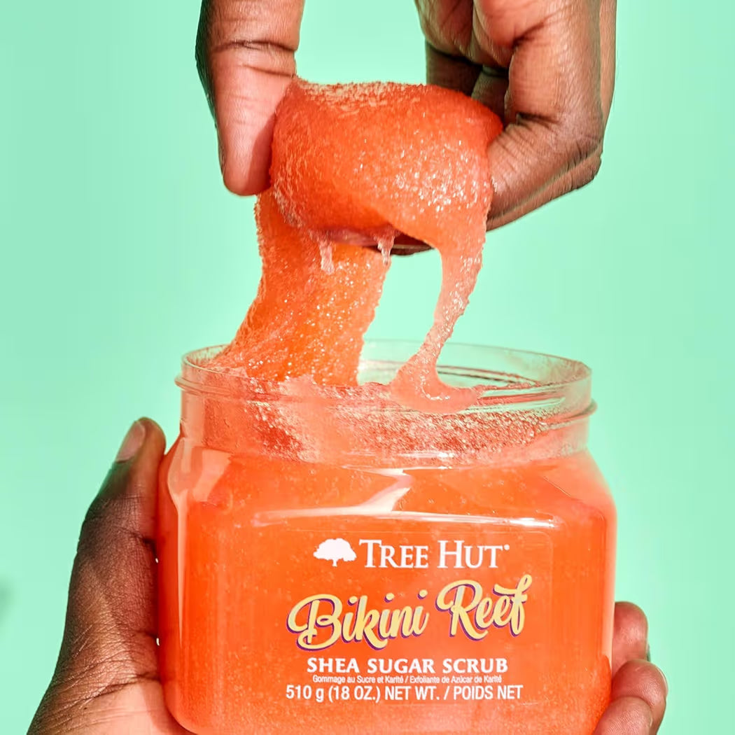 HAMYNAT Tree Hut Bikini Reef Shea Sugar Scrub with a thick, coral-coloured exfoliating texture being held by hand