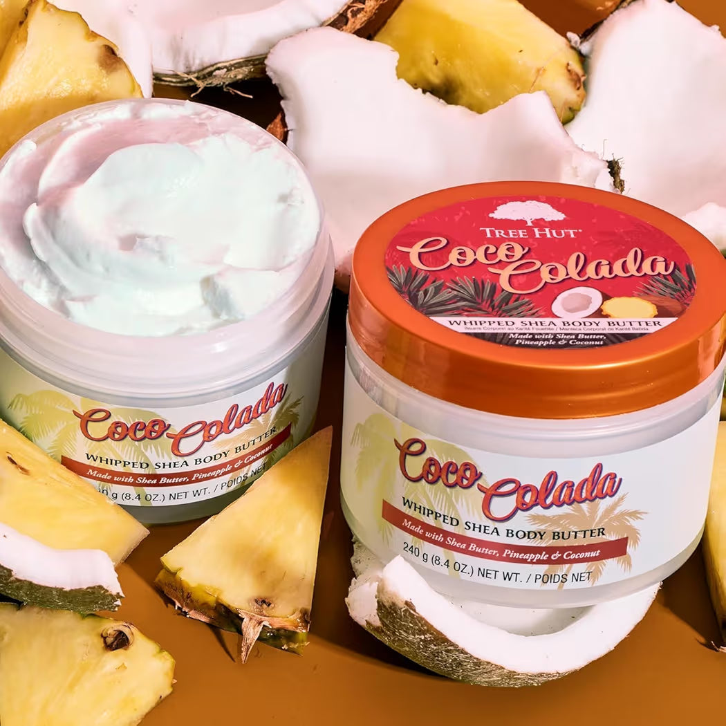 HAMYNAT Tree Hut Coco Colada whipped shea body butter jars surrounded by fresh pineapple and coconut pieces.