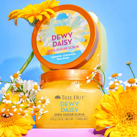HAMYNAT Tree Hut Dewy Daisy Shea Sugar Scrub jars surrounded by fresh yellow daisies and chamomile flowers
