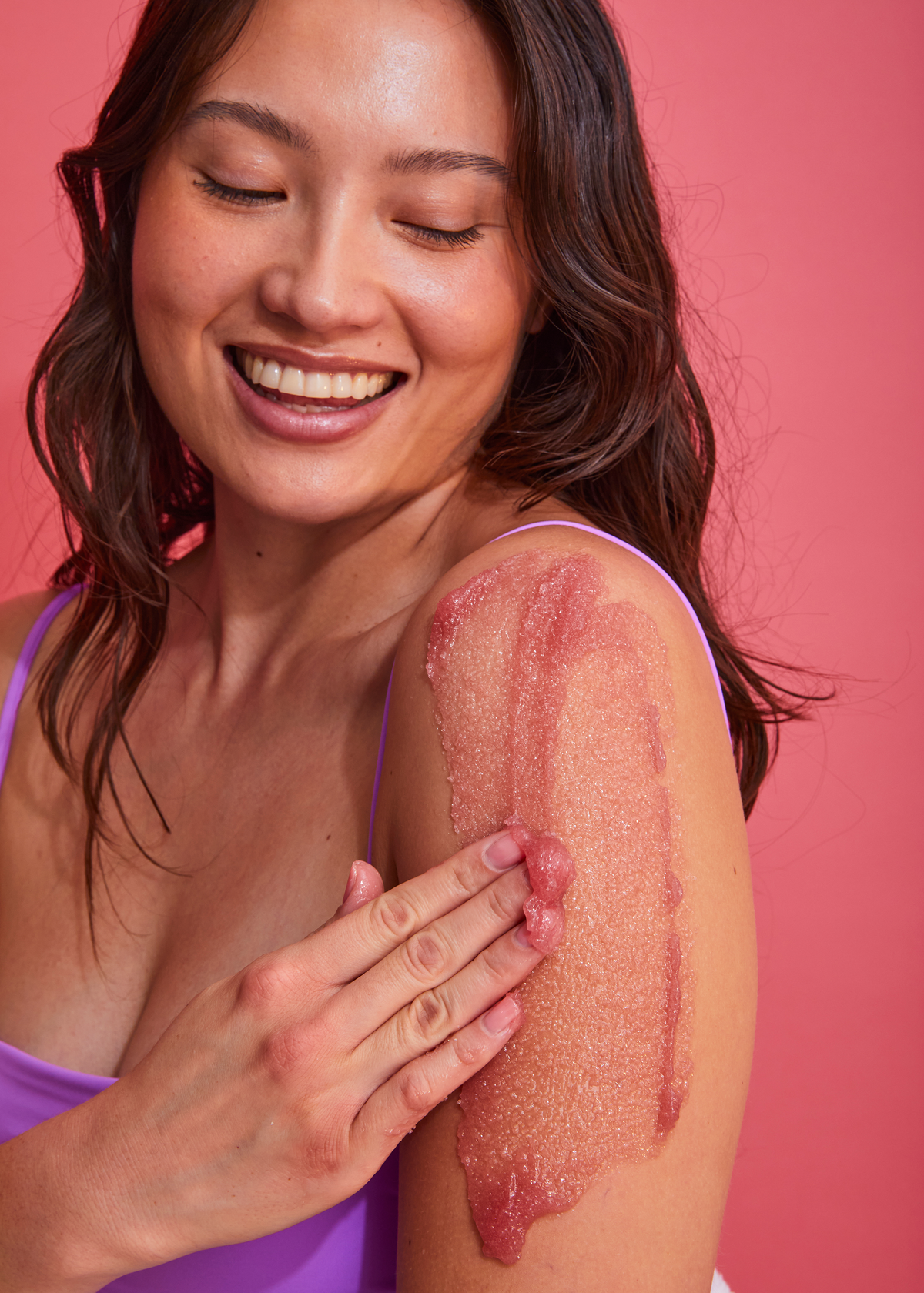 Model applying Tree Hut Enchanted Jasmine sugar scrub to her arm