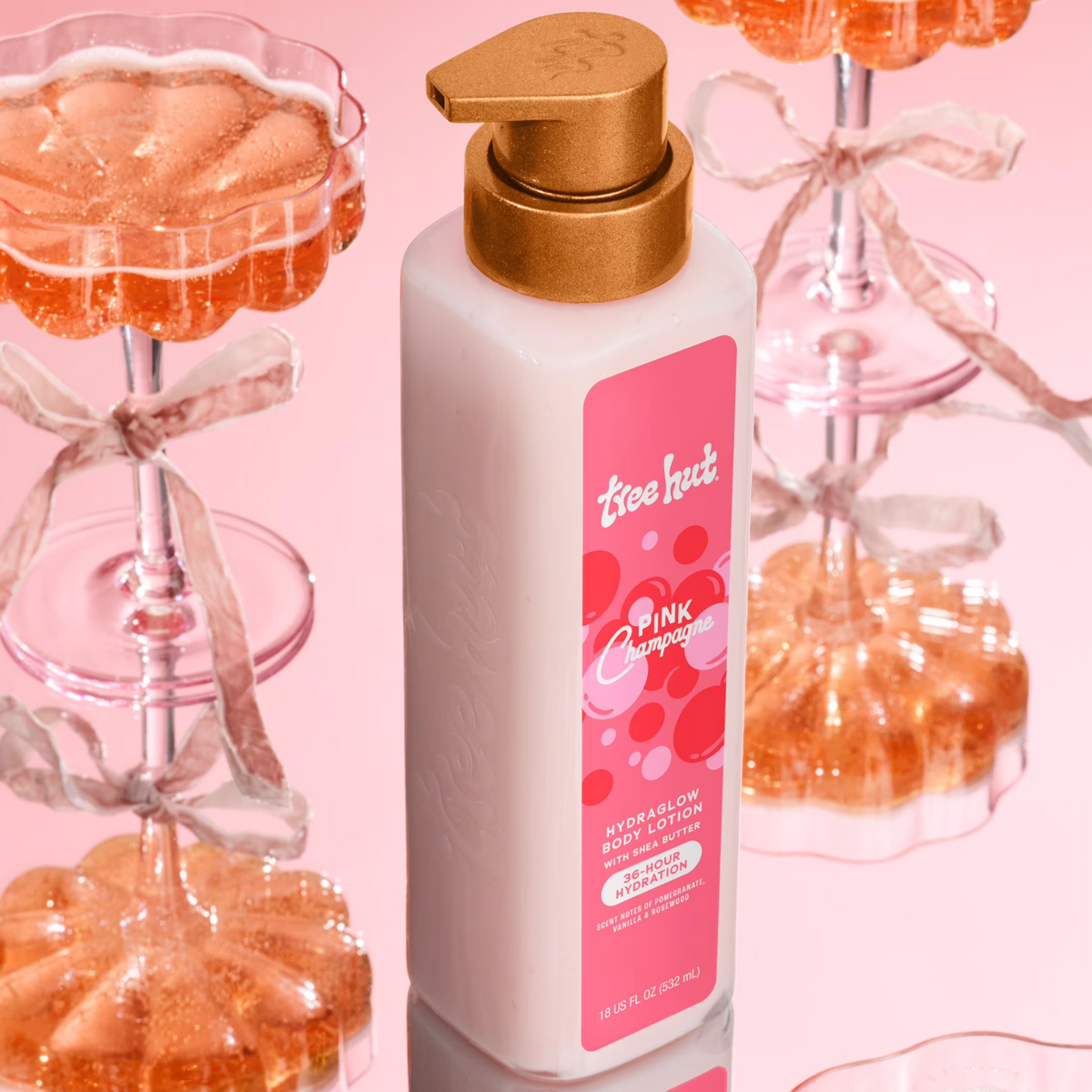 Tree Hut Pink Champagne Hydraglow Body Lotion beside champagne glasses