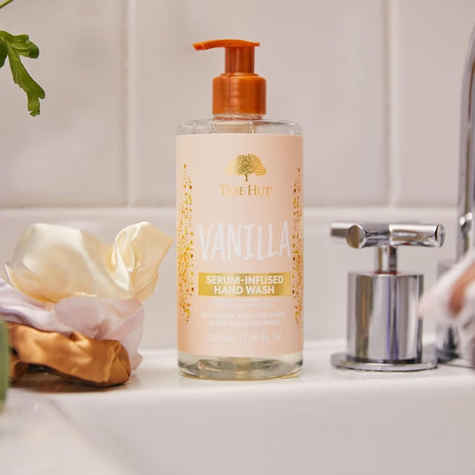 HAMYNAT Tree Hut Vanilla serum-infused hand wash in a clear pump bottle on a bathroom sink with a silk scrunchie.
