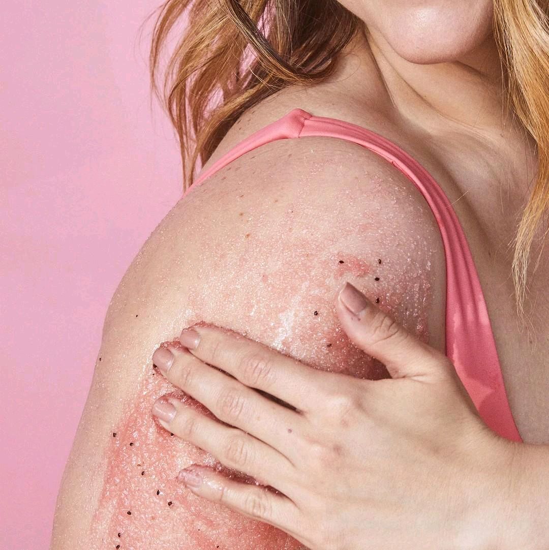 HAMYNAT Tree Hut Watermelon Shea Sugar Scrub being applied to a woman's shoulder for gentle skin exfoliation