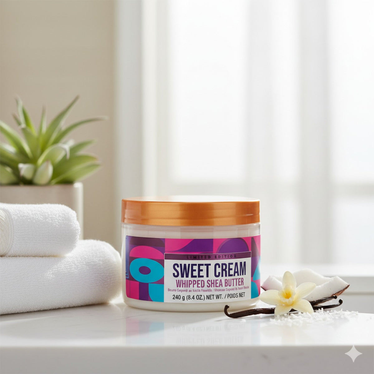 Tree Hut Sweet Cream Whipped Shea Body Butter 240g jar beside white towels, vanilla flower and coconut in a bathroom setting
